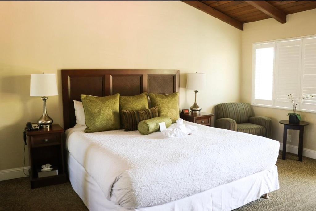 帕罗奥多乡村汽车旅馆的卧室配有一张白色大床和两把椅子