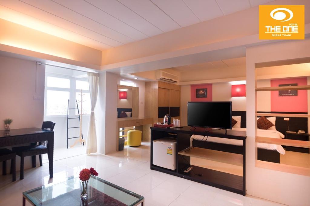 素叻素叻完美酒店的带电视的客厅和用餐室