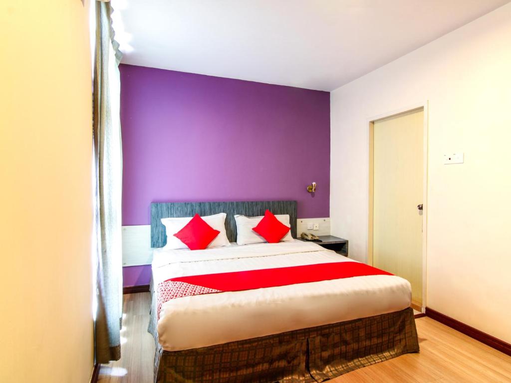 山打根Super OYO 43930 Hotel Esplanade的一间卧室配有一张大床和紫色墙壁