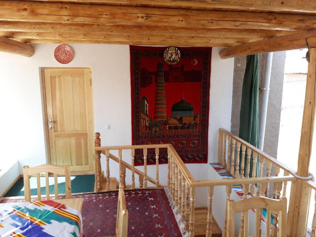 希瓦KHIVA ABDULLA Guest House的一间设有楼梯的房间,墙上挂着一幅画
