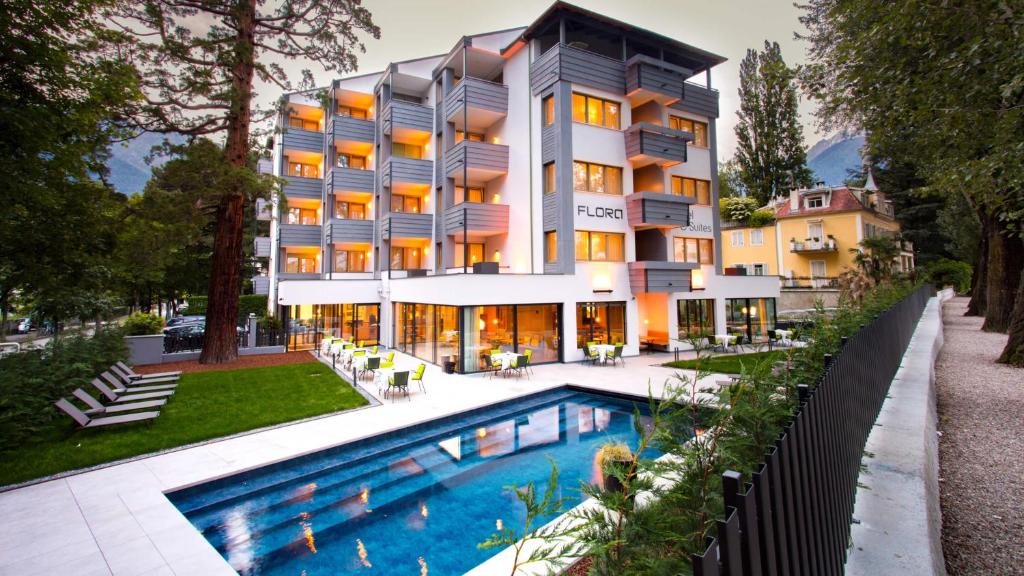梅拉诺Flora Hotel & Suites的大楼前设有游泳池的酒店
