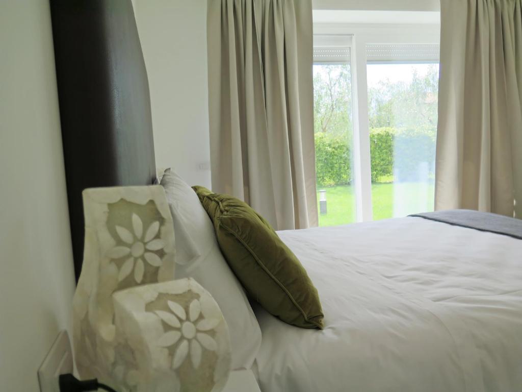 托尔博莱Casa 32的卧室配有带枕头的床铺和窗户。