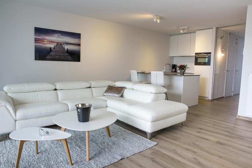 科克赛德Design appartement Zeelaan Koksijde的客厅配有白色的沙发和桌子