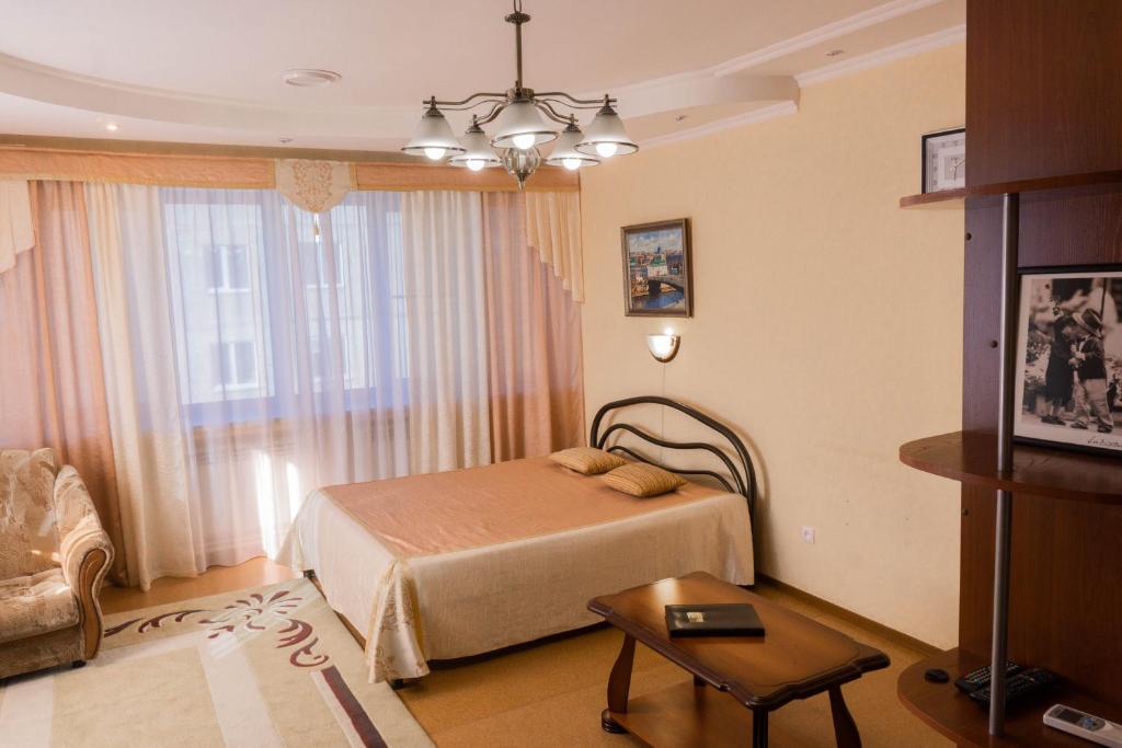 鄂木斯克Hotel Na Svetlom的一间卧室配有一张床、一张桌子和一个窗户。