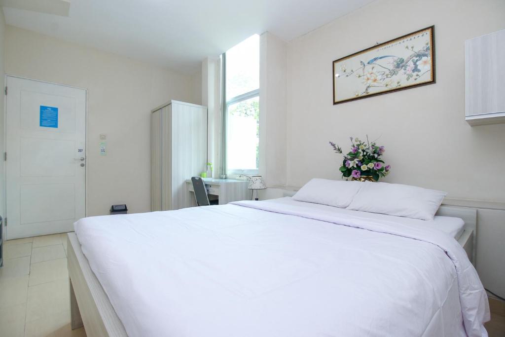 雅加达Blossom Resident Blok M的白色的客房内的一张大白色床,设有窗户