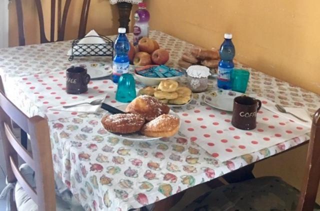 Albiano伊尔梅洛格兰诺住宿加早餐旅馆的桌子,桌子布,连带甜甜圈和瓶装水
