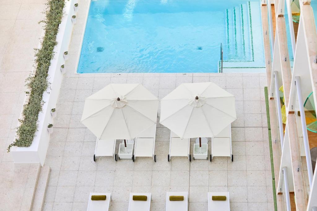 帕尔马海滩杜纳斯布兰卡斯HM酒店的游泳池畔两把白色遮阳伞的顶部景色