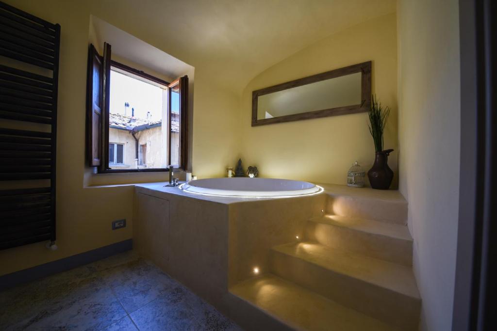 渥尔特拉Il Sogno di Annalisa Suite的一间带大浴缸和窗户的浴室