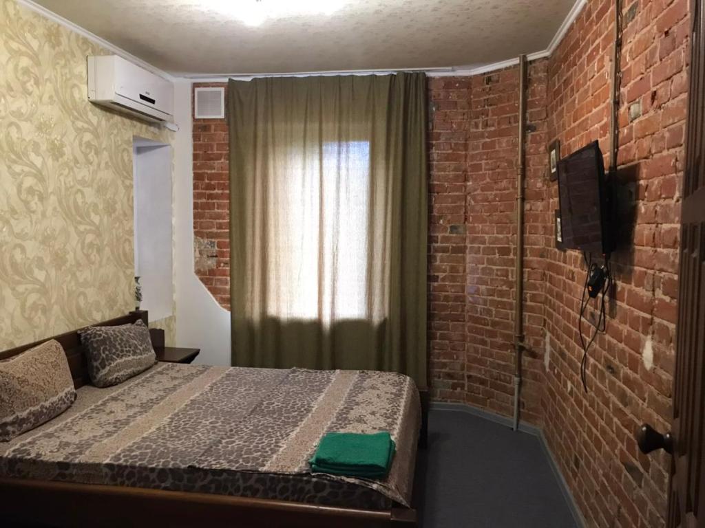 哈尔科夫Moskovs'kyi Avenue 41的一间卧室设有一张床和砖墙