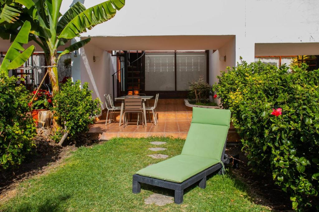 莫甘Flatguest PR Beach - Terrace + Garden + 24H的房子院子中的绿椅