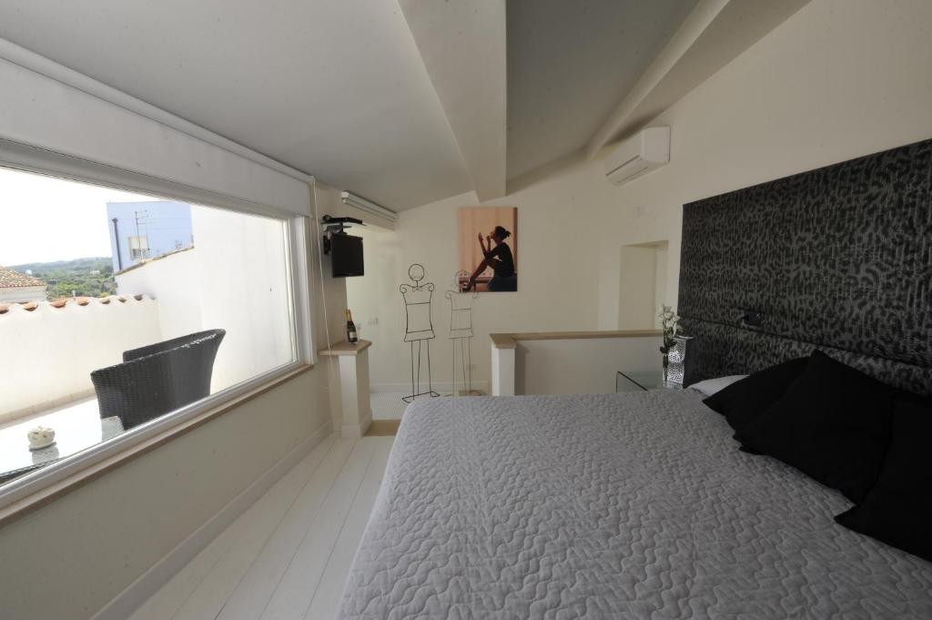 罗迪-加尔加尼科精英15号大厦旅馆的一间卧室设有一张床和一个大窗户