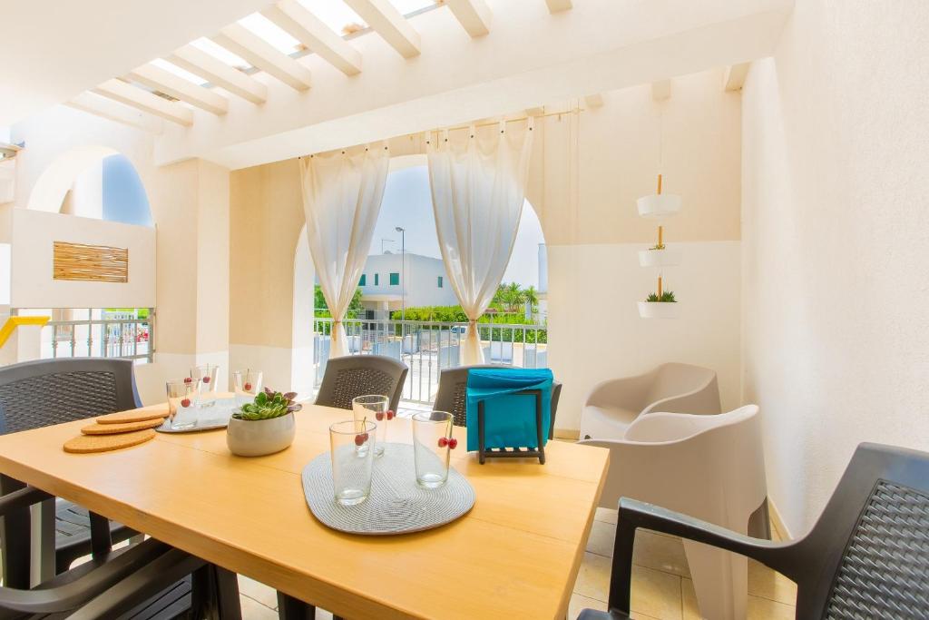 托雷桑塔萨宾娜Appartamento Cristallo的一间带木桌和椅子的用餐室