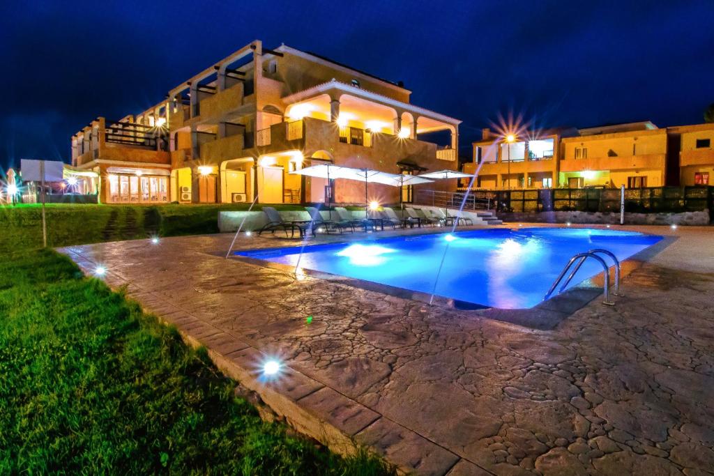 瓦雷多利亚阿巴依达酒店的一座游泳池,在晚上在建筑物前