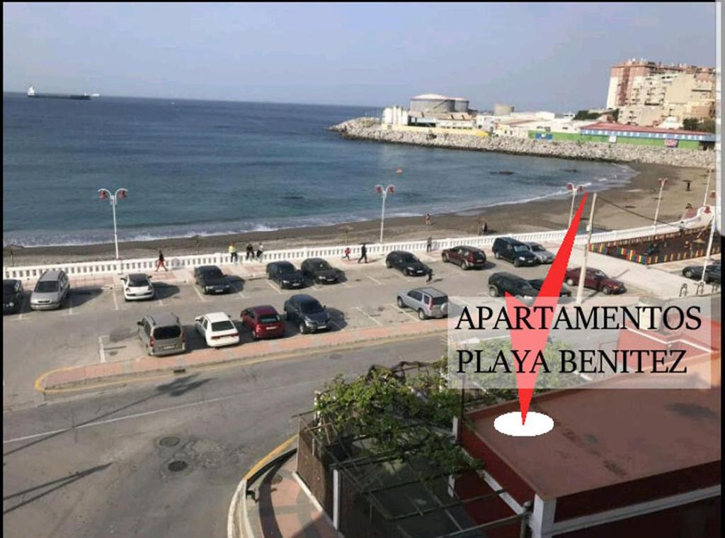 休达Apartamentos Playa Benitez的享有毗邻大海的停车场的景致