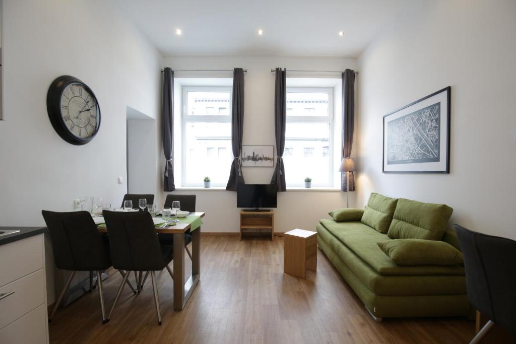 维也纳Vienna Gold Apartments - contactless check in的客厅配有绿色沙发和桌子
