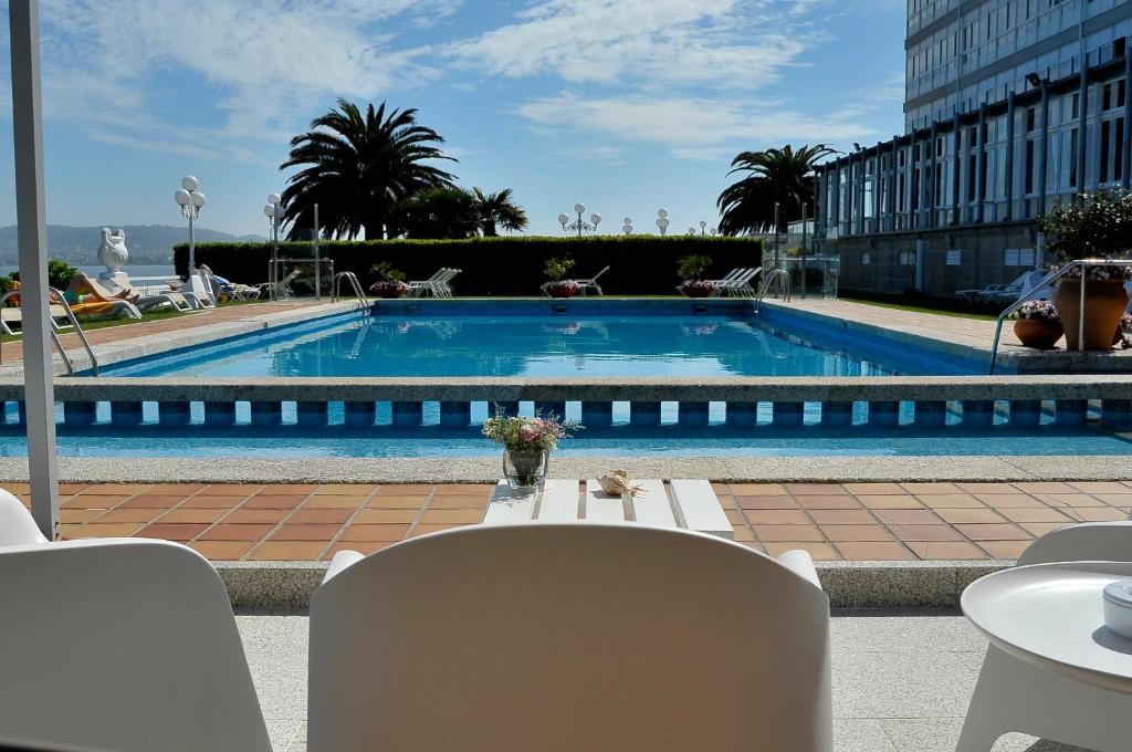 德拉托亚岛托亚塔拉索卢克索酒店的一个带桌椅和桌椅的大型游泳池