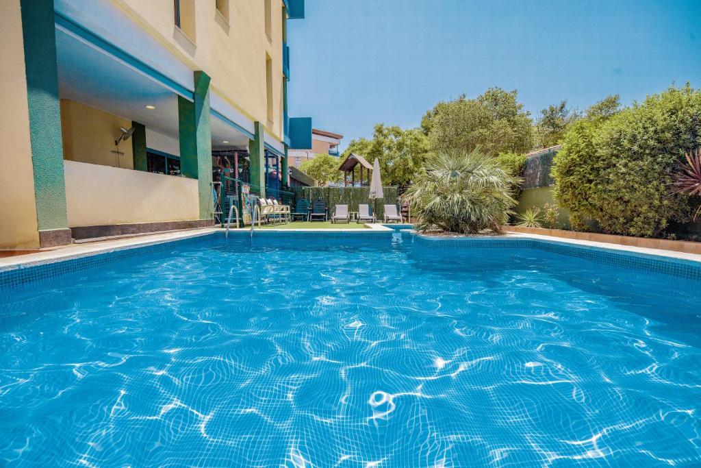 坎布里尔斯伦托马尔科斯塔福德公寓的一座大型蓝色游泳池,位于大楼旁边