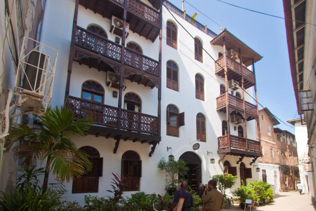 桑给巴尔阿斯米尼宫酒店的白色的建筑,在街上设有阳台