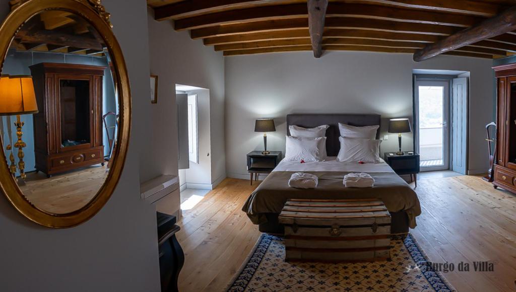维迪堡Burgo da Villa的一间卧室配有一张大床和镜子