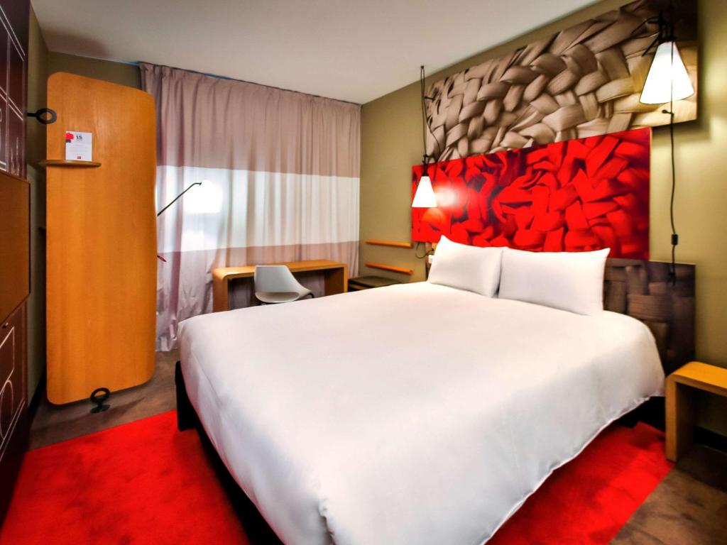拉巴特拉巴特阿格达尔宜必思酒店的酒店客房设有一张白色大床和红色床头板