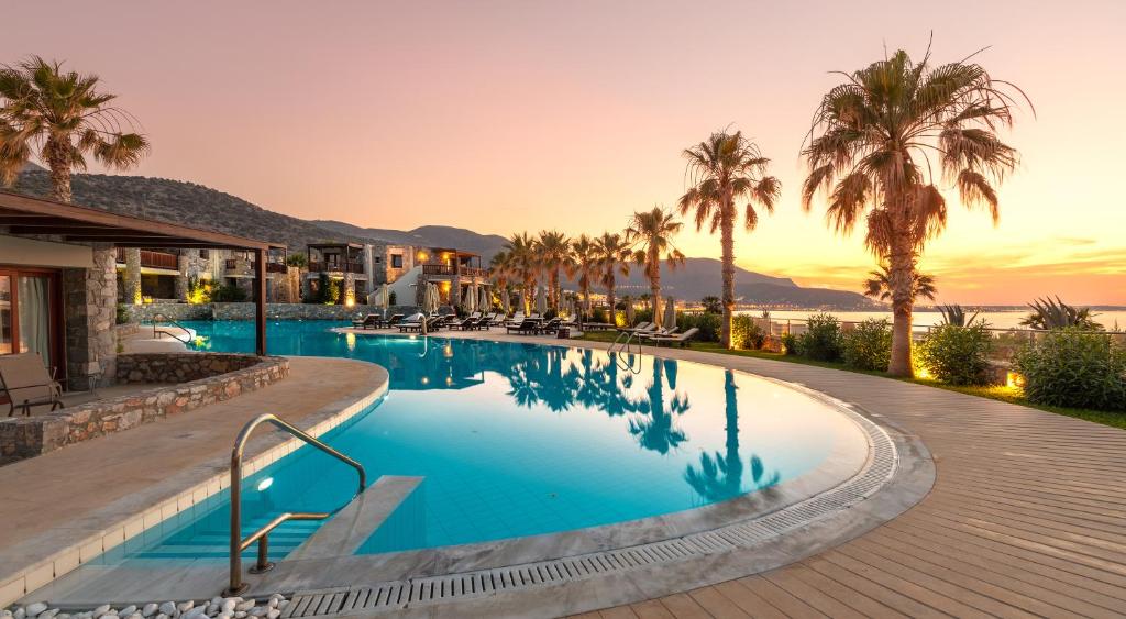 玛利亚Ikaros Beach, Luxury Resort & Spa - Adults Only的棕榈树度假村的游泳池