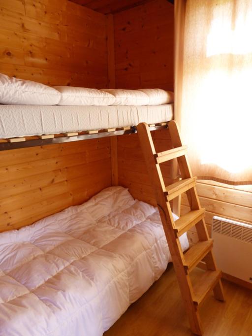 Genouillac塔波尔蒙格朗皮尔宾馆的一间卧室设有两张双层床和梯子