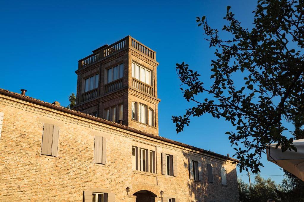 Santa VenerandaIl Pignocco Country House的砖楼顶上高高的钟楼
