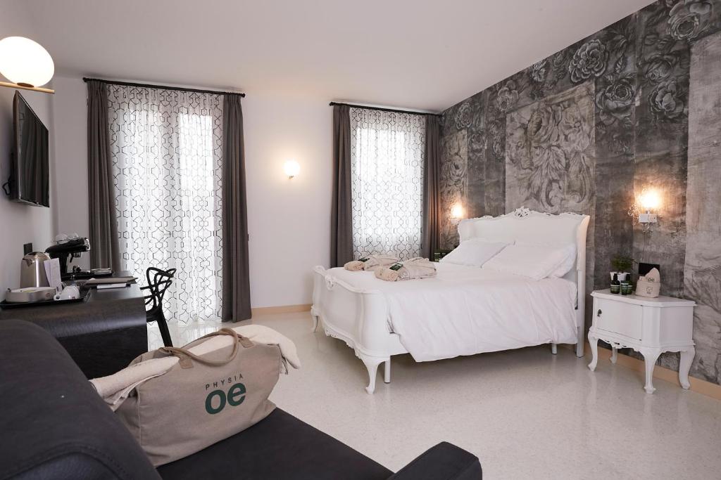 维琴察Antica Pusterla Relais de Charme的卧室配有一张白色的大床和一张沙发。