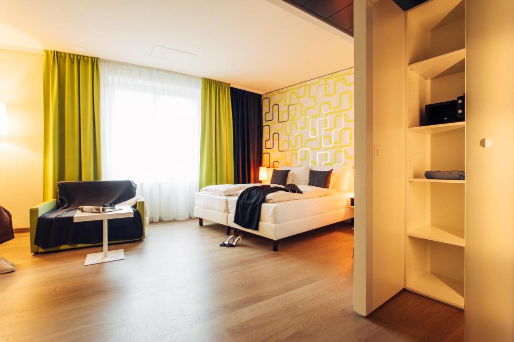 多恩比恩harry's home hotel & apartments的卧室配有床、椅子和窗户。