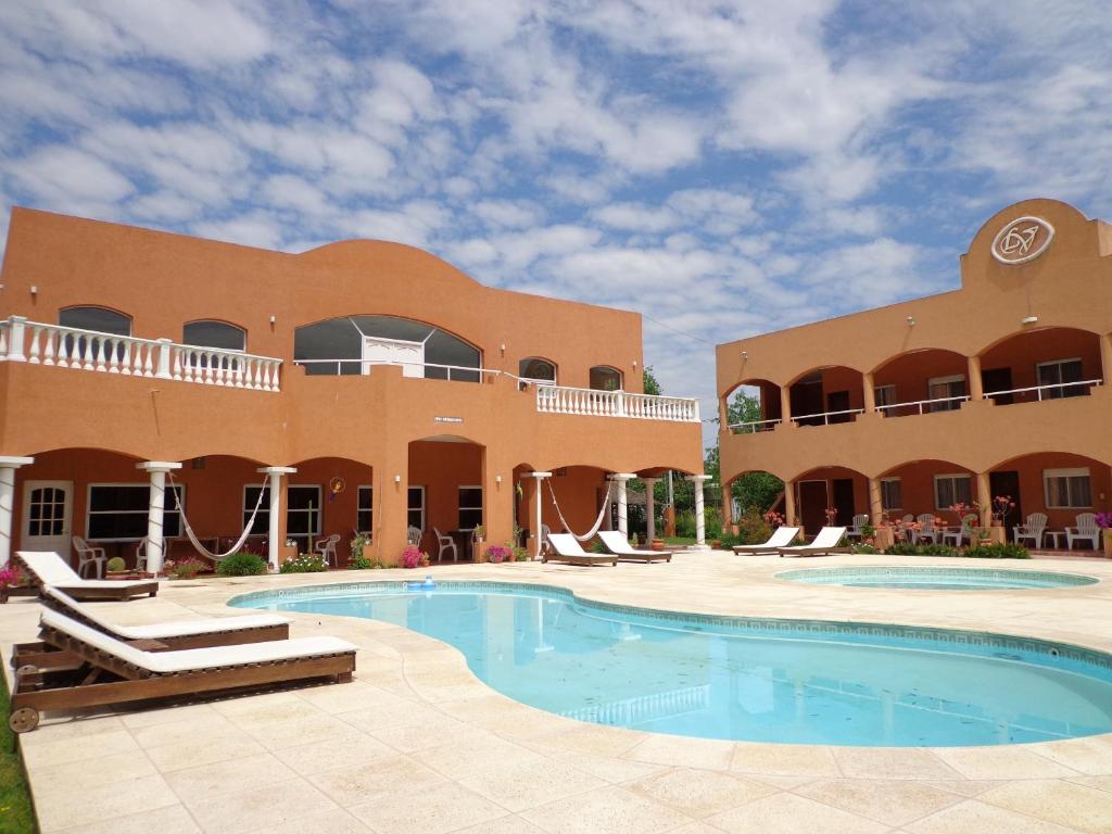 圣米格尔-德尔蒙特Las Victorias Apart Hotel的一座带游泳池的度假村,位于一座建筑前