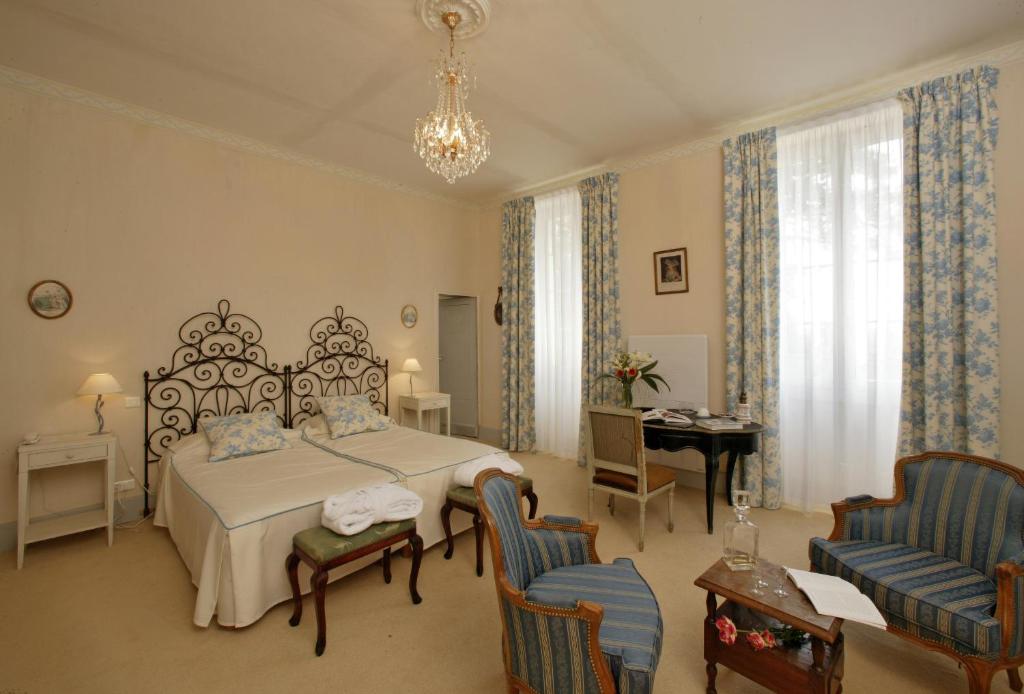圣保罗－代斯皮圣让庄园酒店的卧室配有一张床和一张桌子及椅子