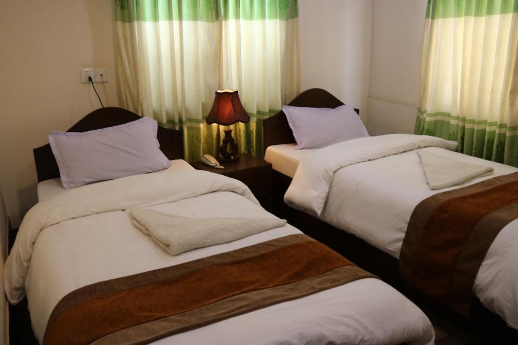 加德满都加德满都和平宾馆 的客房设有两张单人床和一盏灯。