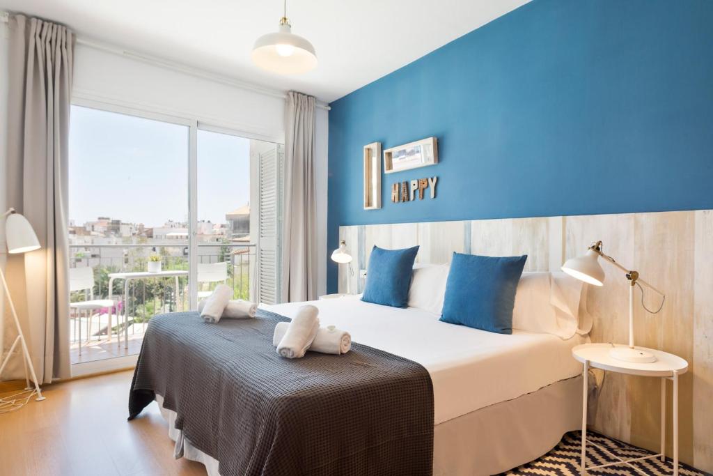 锡切斯Sitges Group Soul的一间卧室配有一张带蓝色墙壁的大床