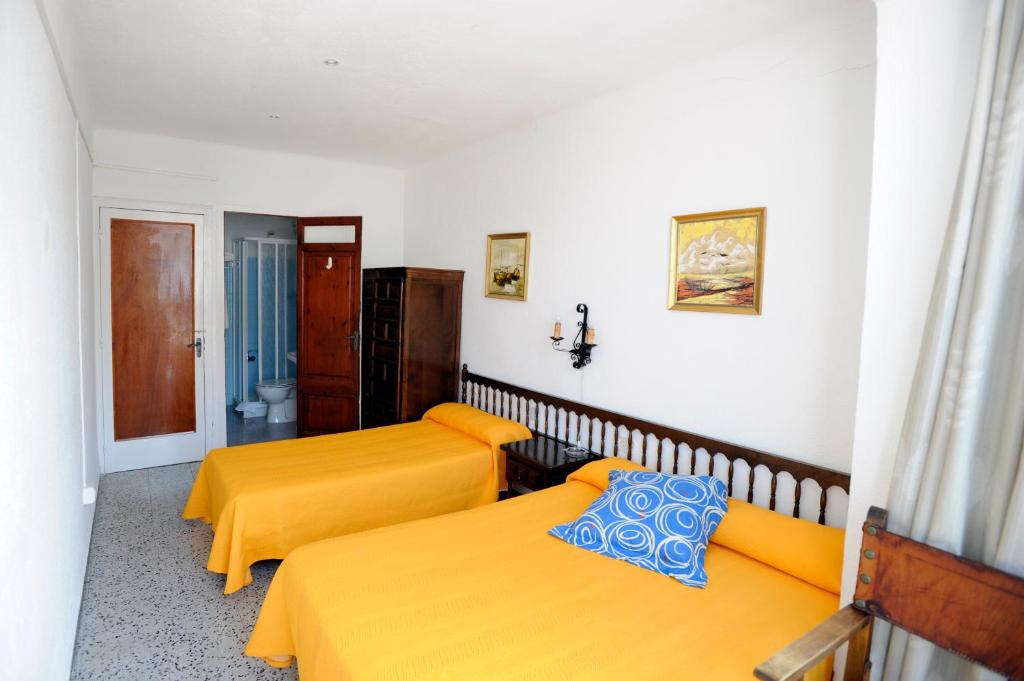 圣卡洛斯拉腊皮塔坎玛丽尼斯旅馆的配有黄色床单的客房内的两张床