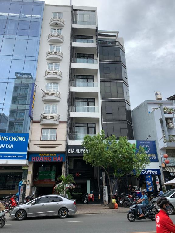 胡志明市Gia Huyền Hotel的一座高大的建筑,前面有一辆汽车