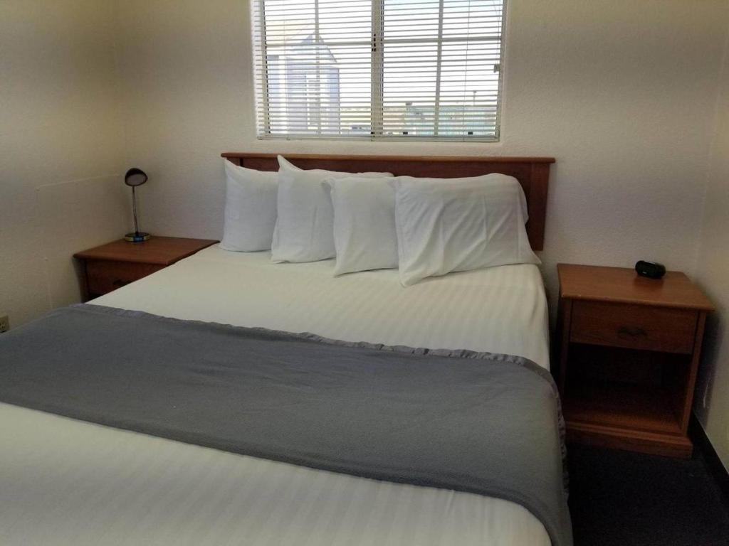瓦莱068A Cozy Studio Grand Canyon South Rim Sleeps-2的一间卧室配有一张带白色床单的床和一扇窗户。
