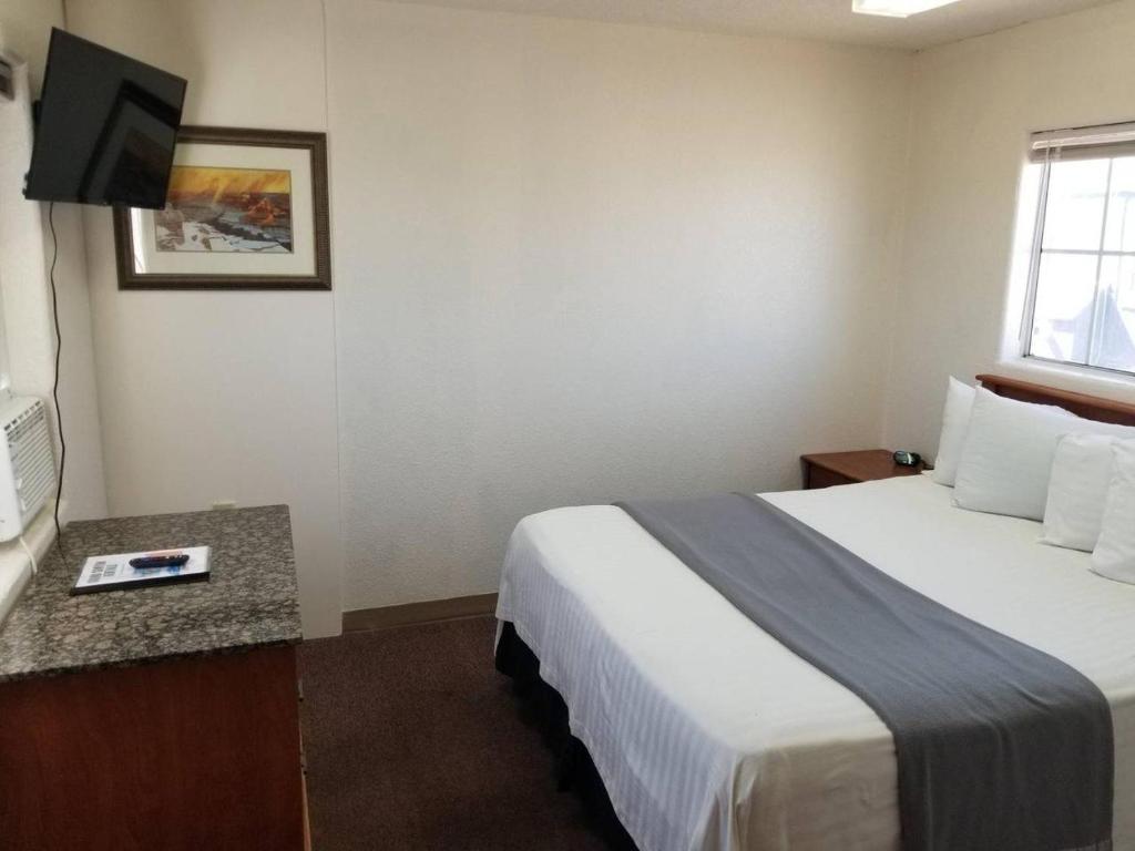 瓦莱068C Cozy Studio Grand Canyon South Rim Sleeps-2的配有一张床和一台平面电视的酒店客房