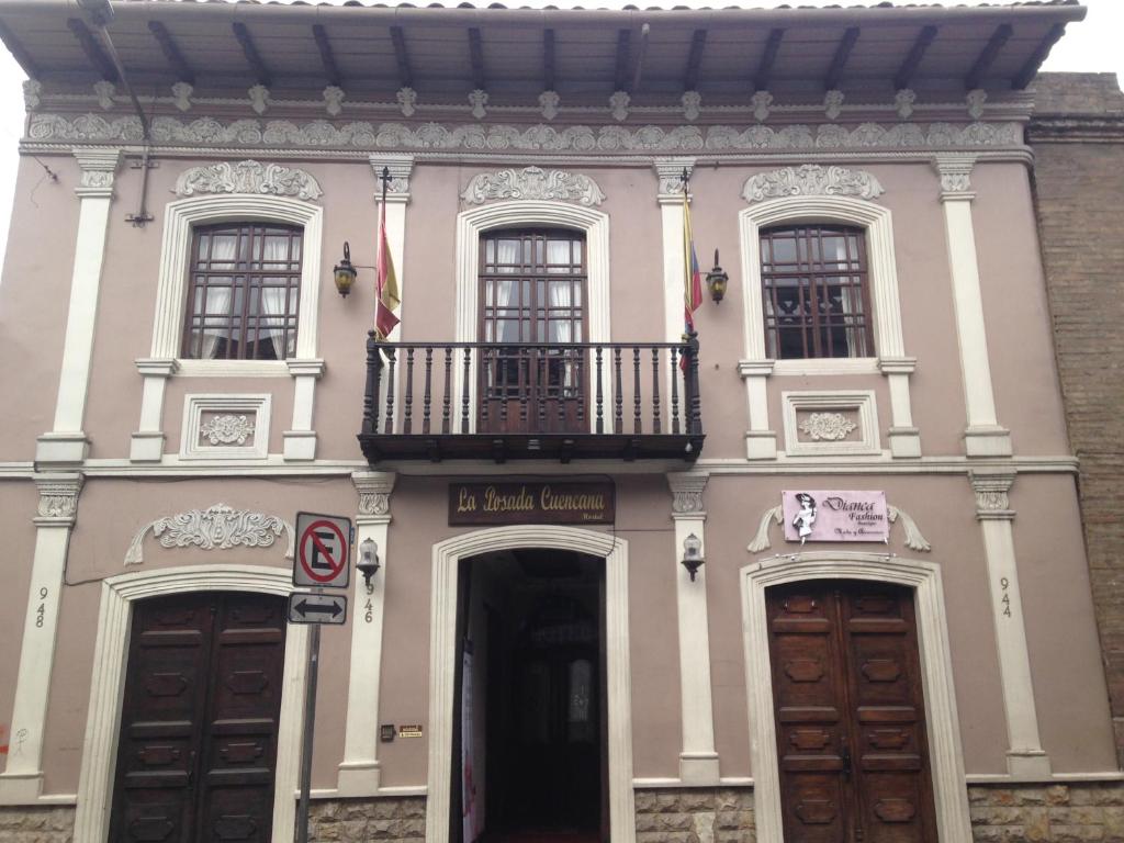 昆卡La Posada Cuencana Hotel Boutique的粉红色的建筑,设有阳台和2扇门