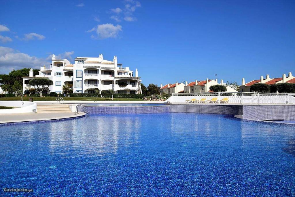 维拉摩拉Charming Apartment with Private Garden & Pool的大型白色建筑前的大型游泳池