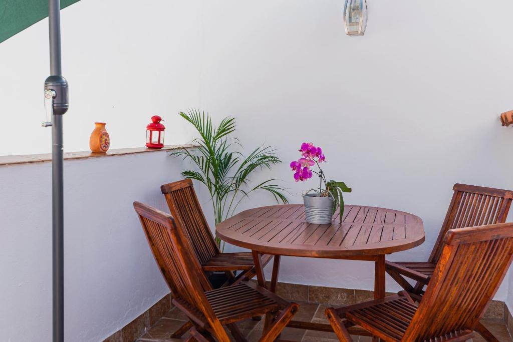 马拉加La Buhardilla de Olivia的一张木桌、椅子、桌子和鲜花