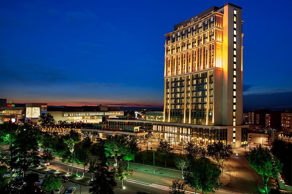 马拉蒂亚Movenpick Hotel Malatya的一座高大的建筑,城市里灯火通明