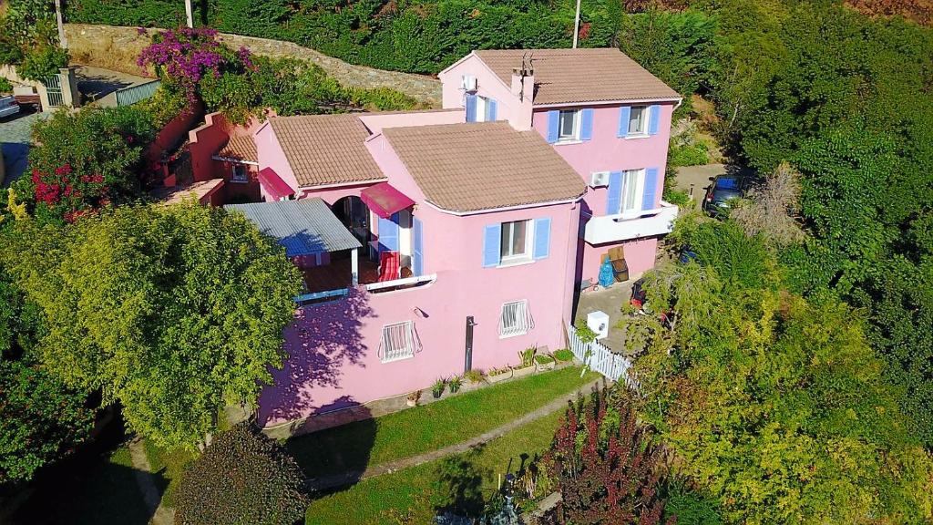 比居格利亚Chambres d'hôtes Villa bella fiora的山丘上方的粉红色房子