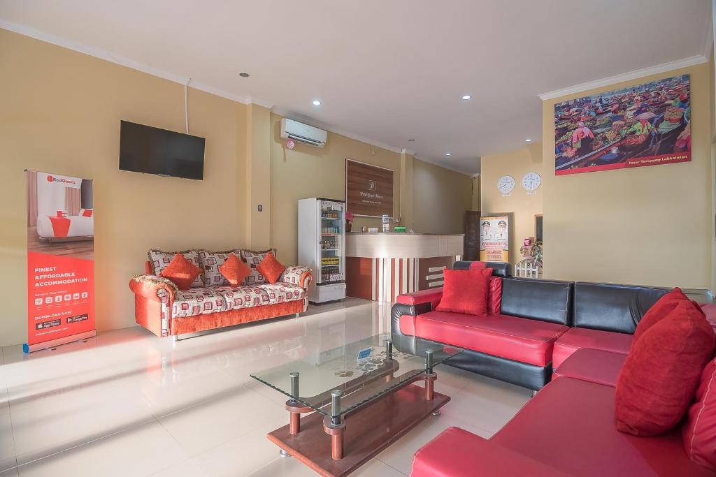 BanjarbaruRedDoorz Plus near Syamsudin Noor Airport 3的客厅配有两张沙发和一台电视机