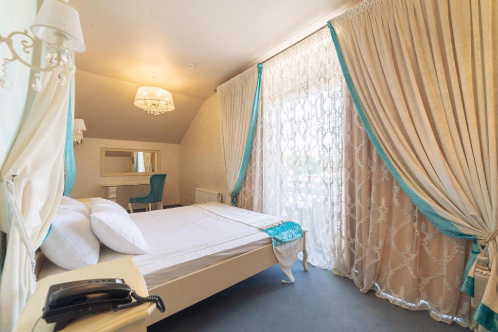 克拉斯诺达尔Гостиница Альвита Краснодар Центр的一间卧室配有床和带窗帘的窗户