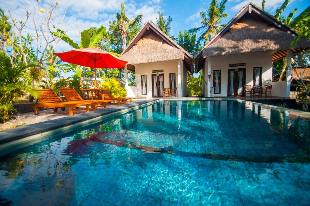 珀尼达岛Japa Bungalow的别墅 - 带红色遮阳伞的游泳池