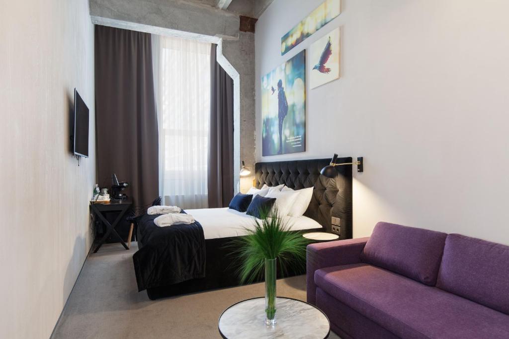 维尔纽斯维尔纽斯路普酒店的酒店客房设有一张床和一张紫色沙发