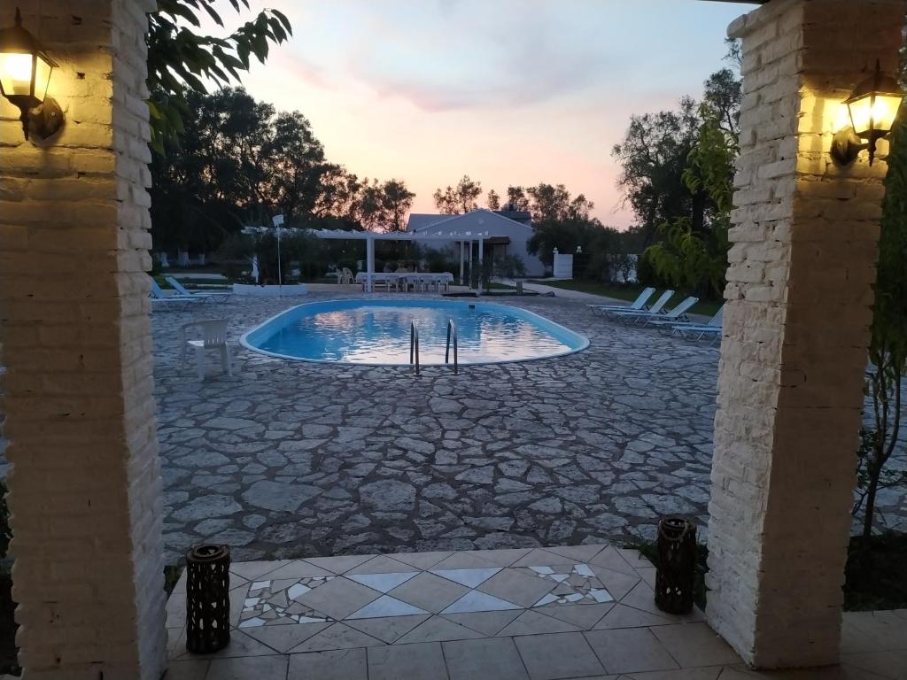 莱夫基米Alykes Family Resort的庭院内的游泳池,设有石头庭院