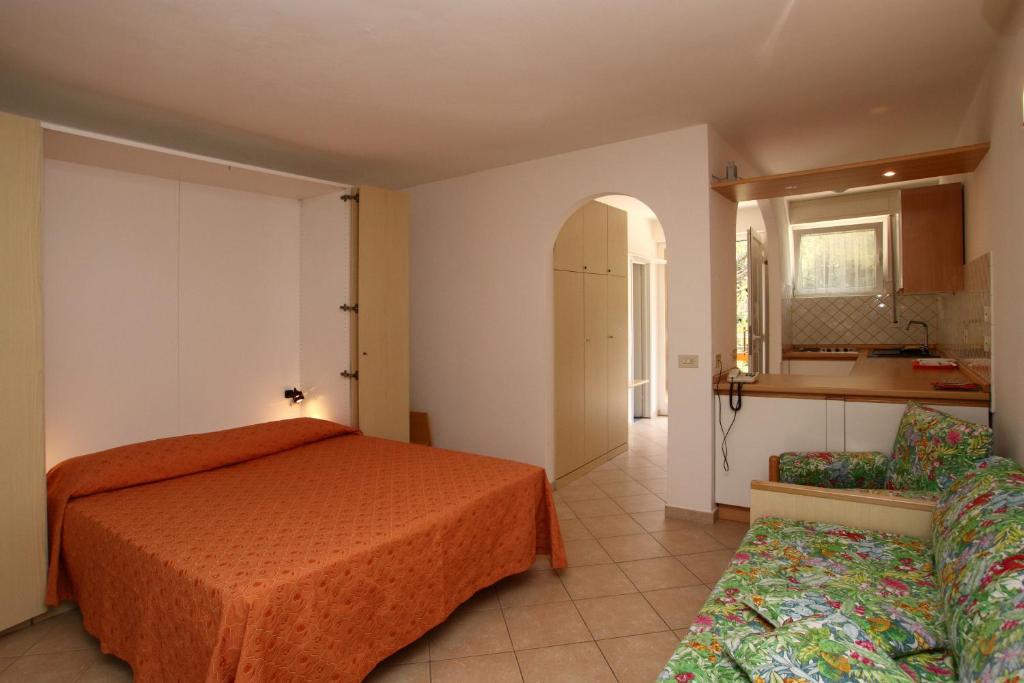 毕博纳的码头卡萨帝卡恰公寓的一间带橙色床的卧室和一间厨房