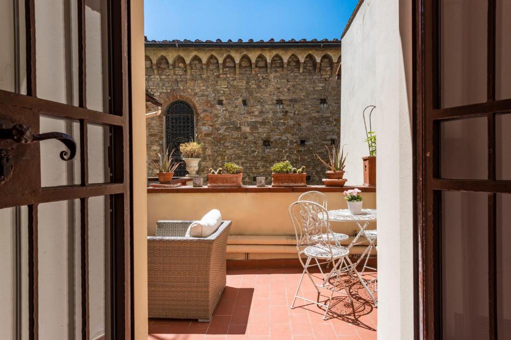 佛罗伦萨圣雷米希奥住宿加早餐旅馆的通往带桌椅的阳台的开放式门