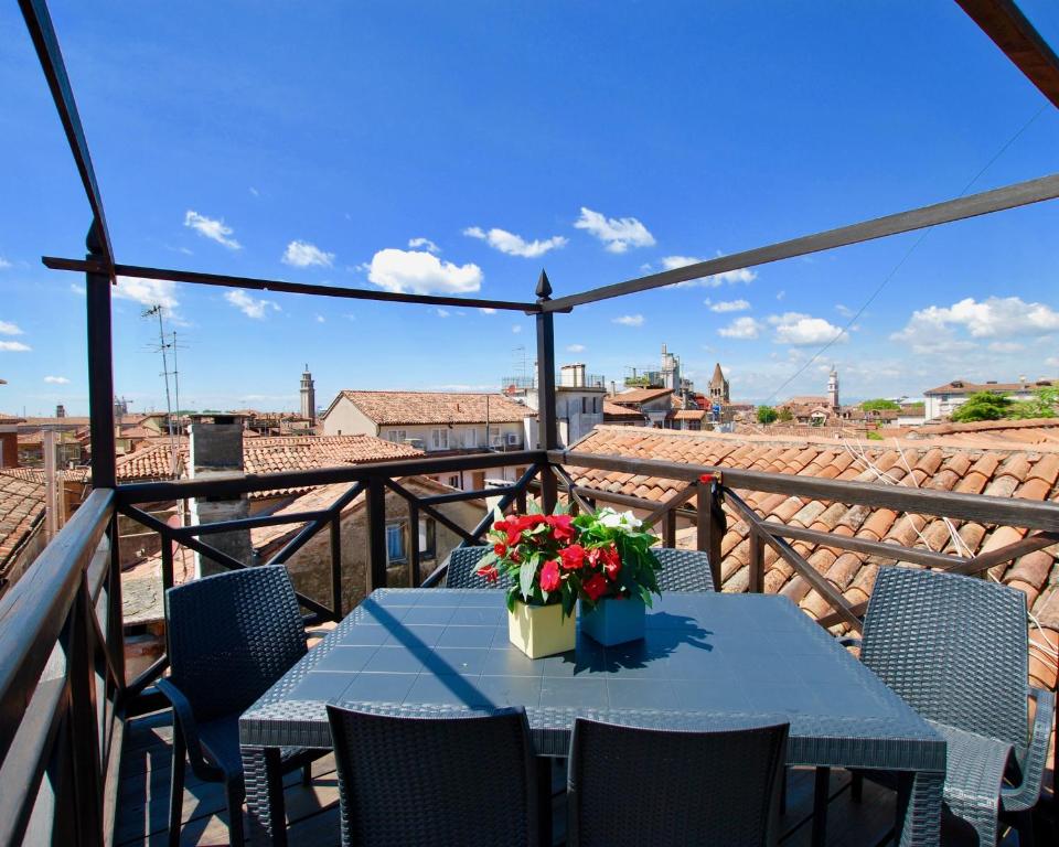 威尼斯CA GRIMANI private terrace的阳台上的桌子上摆放着鲜花